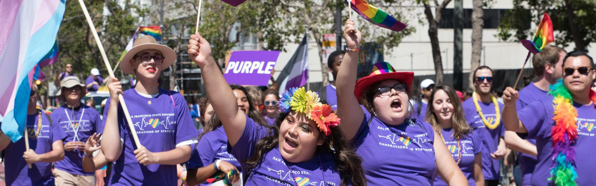 Students with rainbow flags outdoors on campus
